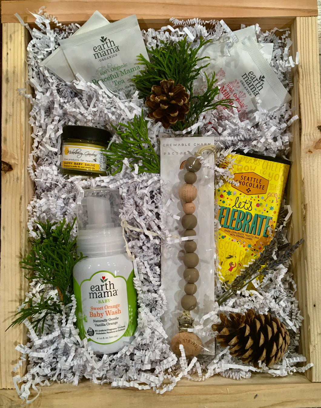 Welcome baby with this thoughtful gift box/basket - Organic baby wash from Earth Momma, Chewable charm teething pacifier clip, Mickleberry Gardens happy baby  sauce, Assorted wellness teas  and a  chocolate truffle bar that says 