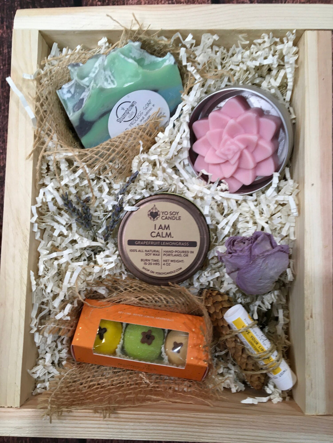 Sample box containing body butter, soap, soy candle, chocolate truffles, and lip balm.