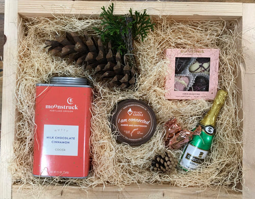 Sample box containing a soy candle, drinking chocolate, chocolate hearts, and chocolate champagne.