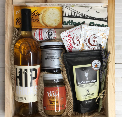 Sample box containing wine, nut butter, coffee, drinking chocolate, salami crackers, and Portland Oregon tea towel.