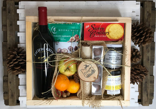 Sample box containing wine, chocolate hazelnuts, chocolate truffles, apples, oranges, honey, jam, salami and crackers. 