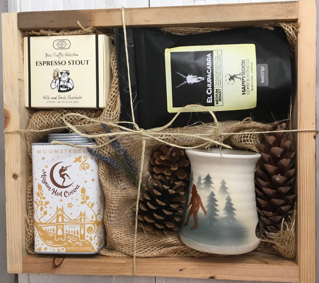 Sample box containing a sasquatch mug, hot chocolate mix, coffee beans, and chocolate truffles.