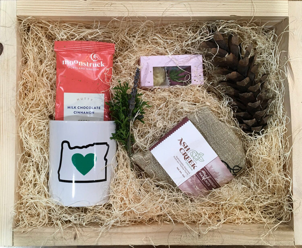 Sample box containing Oregon mug, chocolate hazelnuts, chocolate truffles, and drinking chocolate.